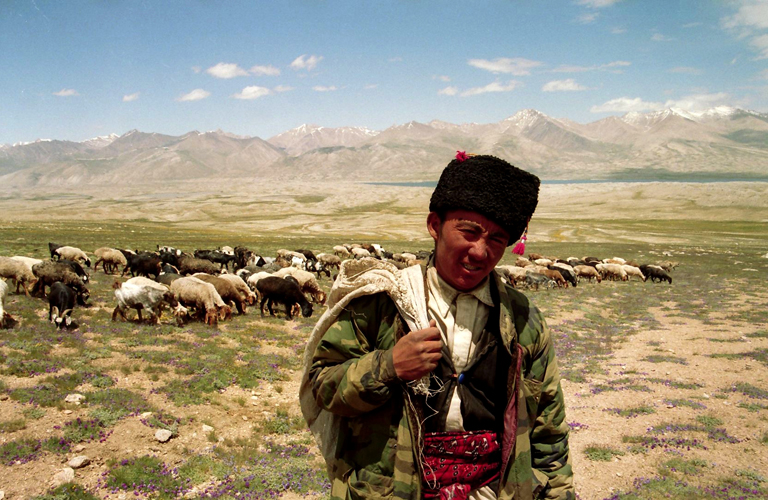 Parcourant le Grand Pamir – <i>pamir</i> signifie « alpage » ou « pâturage » –, ce berger solitaire de Sar Mokol a en charge une centaine de moutons de ce campement de cinq maisons de pisé et quinze yourtes. Derrière lui apparaît la tache sombre du lac Zok Kol, à cheval sur la frontière de l’Afghanistan et du Tadjikistan, et source de l’Amou-Darya, l’antique fleuve Oxus cité par Hérodote. Les rives tadjikes du lac pourtant si proche, tout comme les cimes qui le dominent, restent inaccessibles aux Kirghizes du Pamir, démunis de tous papiers d’identité.