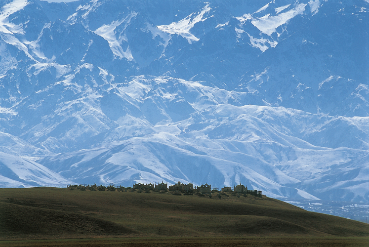 Cimetière sur fond des Tian-Chan : la chaîne Kirghize, vue ici de la région de Merké, domine vertigineusement la steppe (Kazakhstan).